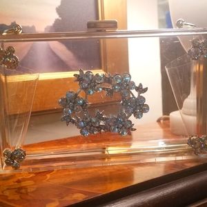 Clear clutch adorned with vintage jewels